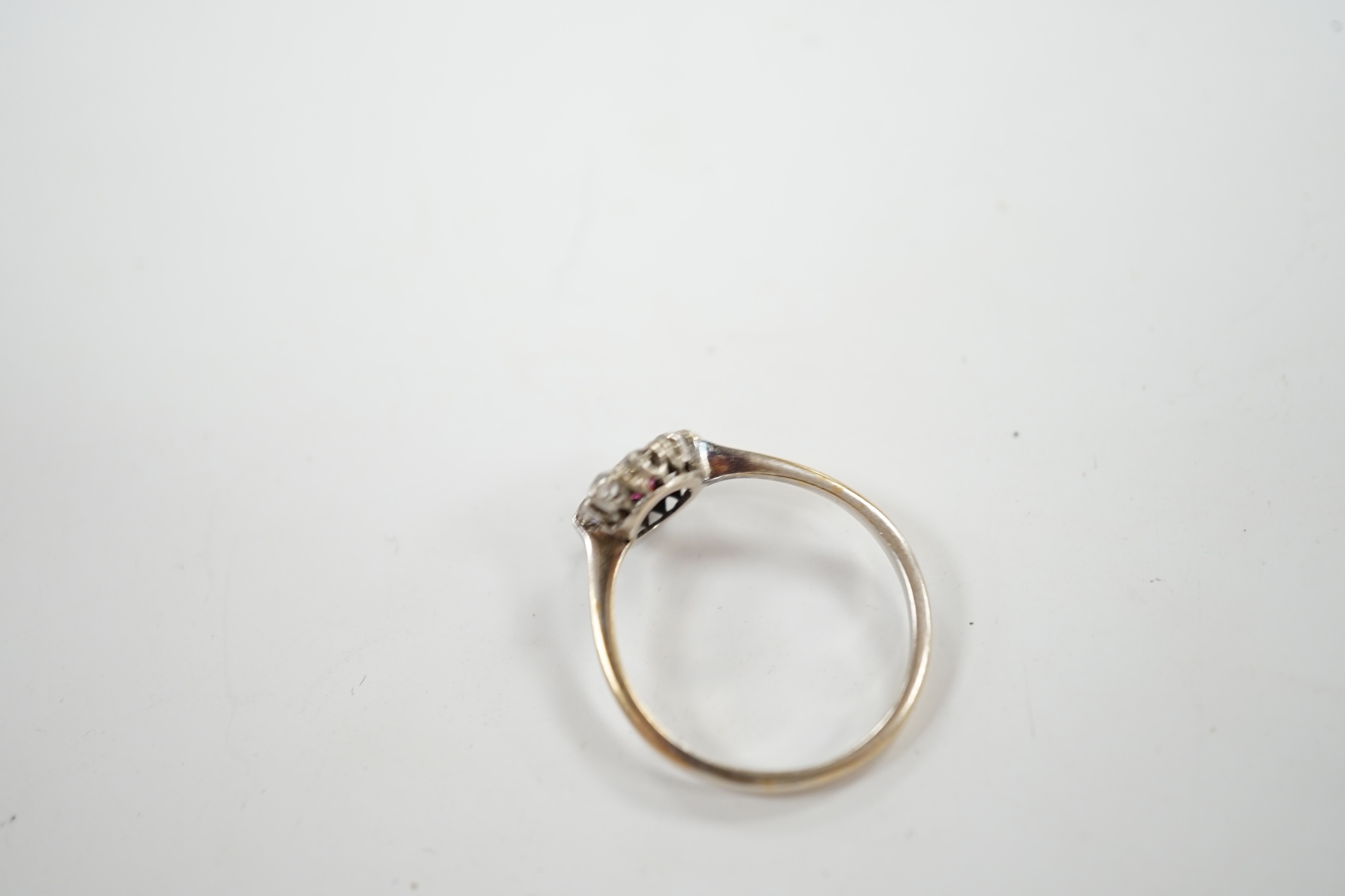 A 1940's 18ct white metal, ruby and diamond set circular cluster ring, size N/O, gross weight 1.9 grams. Condition - fair